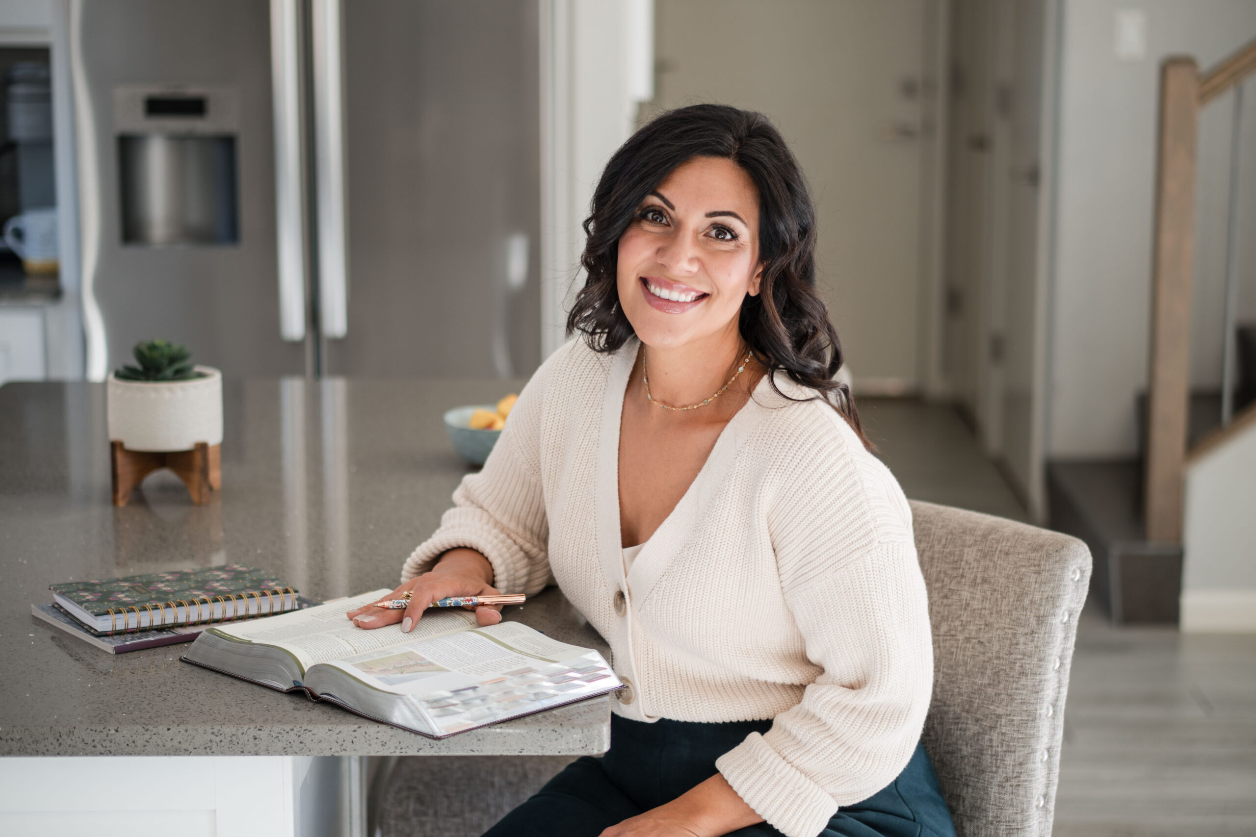 sitting-in-kitchen-with-bible-stefanie-gass The image title is: How-to-Act-as-Christians-in-a-Fallen-World-Biblical-Roadmap-From-Stefanie-Gass-Romans-12