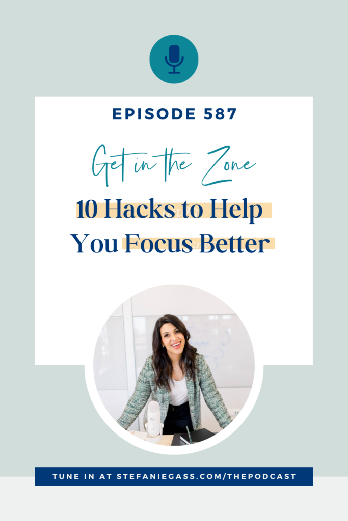 A dark-haired woman with a pale blue jacket is standing at a table with her arms spread apart. She has a microphone in front of her. The Graphic is titled: Episode 587 Get in the Zone: 10 Hacks to Help You Focus Better. The link at the bottom of the graphic is: Tune into stefaniegass.com/thepodcast 
