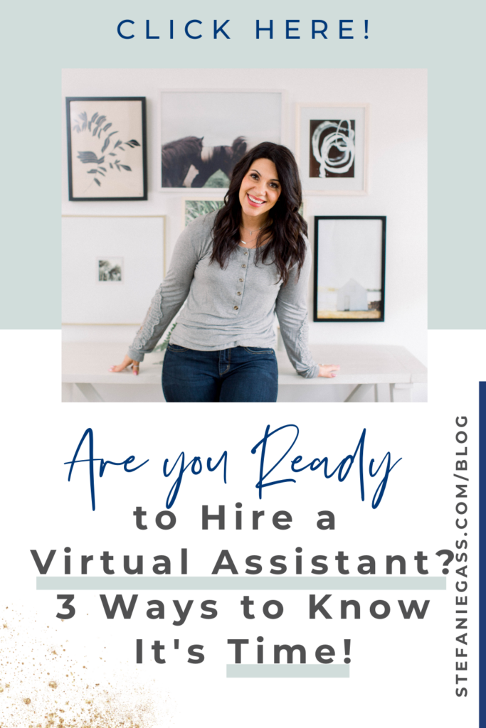 A long dark-haired woman is standing with her arms outstretched, leaning on a desk. She is wearing a gray, long-sleeved, button up top with blue jeans. There are a range of prints in frames behind her that are on the wall. The Title of the graphic is: Are you ready to hire a virtual assistant? 3 ways to know it is time. The link on the right hand side of the graphic is stefaniegass.com/blog