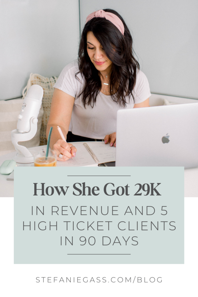 A long, dark-haired woman with a pink headband is writing in a notebook. She is wearing a white t shirt. Her laptop is open in front of her and she has a podcast mic and a glass of orange juice to the side of her. The title of the graphic is How she got 29K in revenue and 5 high ticket clients in 90 days. The link at the bottom of the graphic is stefaniegass.com/blog.