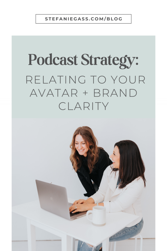 Dark haired woman sitting at her desk with a light brown haired woman leaning over her. Both are looking at a laptop screen. Text in a green box above saying podcast strategy: relating to your avatar and brand clarity.