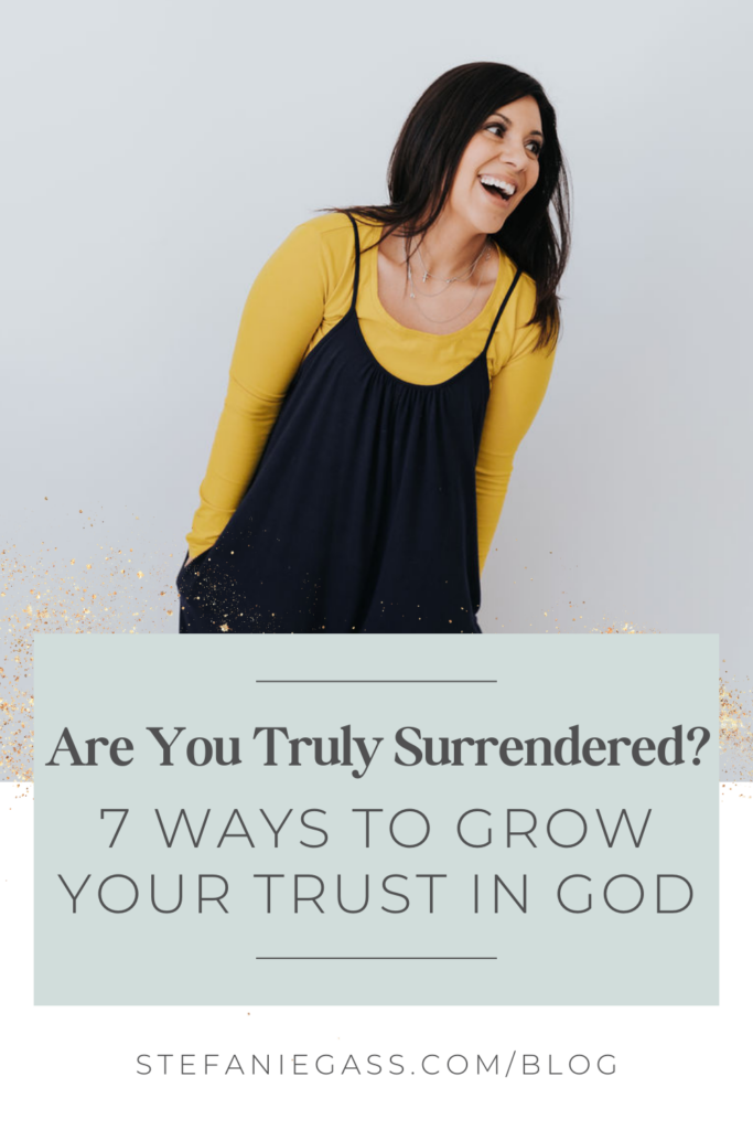 In the background is a Dark haired lady in yellow top and black jump suit with hands in her pockets leaning towards the left of the picture, smiling at someone out of the picture. In the foreground is a green text box with text reading Are you truly surrendered? 7 ways to grow your trust in God. The link is to stefaniegass.com/blog