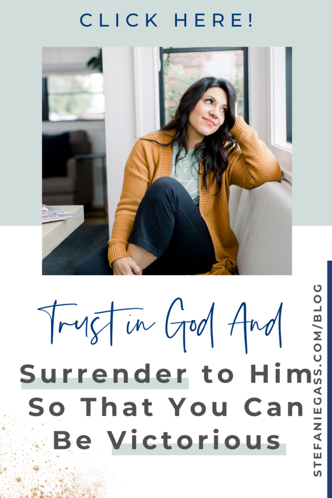 A green and white blocked background. In the foreground is a dark haired lady wearing a mustard jersey and blue trousers sitting on a window seat with her head resting on her left hand and her left leg up. She is resting her right hand on her left heel and looking out the window. The text reads Trust in God and surrender to him so that you can be victorious. Click here. The link is to stefaniegass.com/blog. 