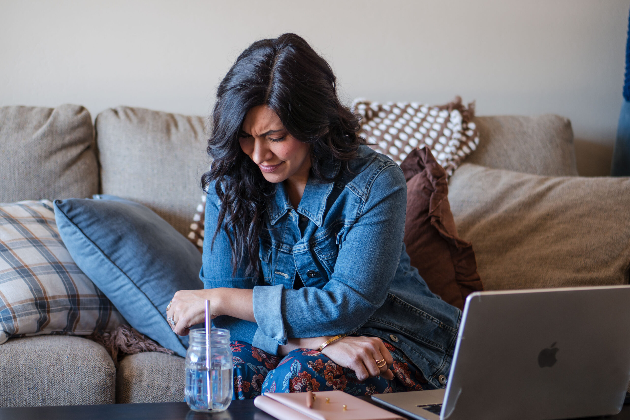 sitting-on-couch-head-down-sad-laptop-on-coffee-table-stefanie-gass The image title is: How-to-Act-as-Christians-in-a-Fallen-World-Biblical-Roadmap-From-Romans-12-Stefanie-Gass