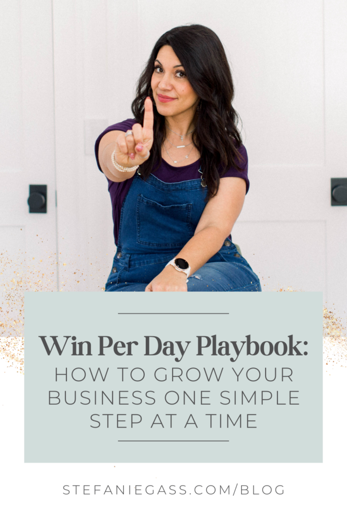 Brown haired woman holding up her pointer finger for the number 1. Text reads: Win per day playbook: How to grow your business one simple step at a time. 