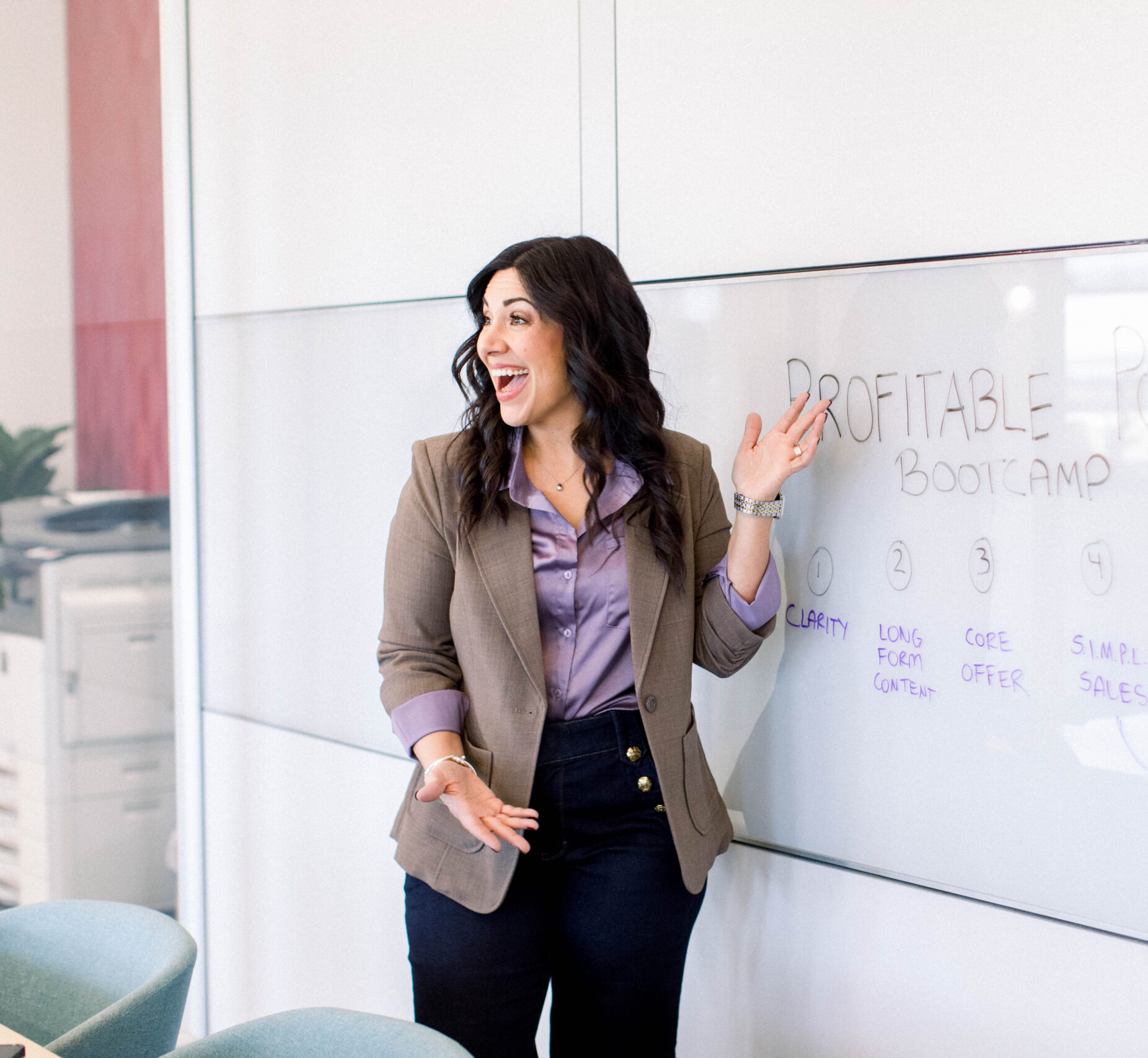 pointing-at-whiteboard-looking-away-smiling-in-office-stefanie-gass The image title is: Ep-719-How-She-Got-Eighteen-Sales-in-Her-First-Live-Launch-With-Tracy-Hoth