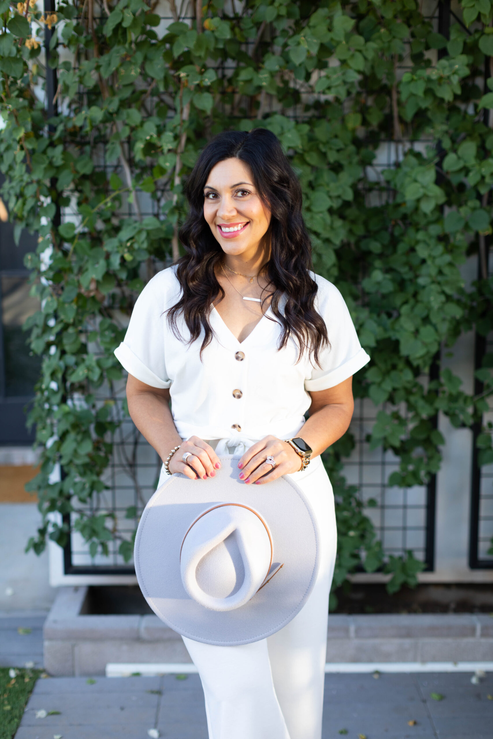 Image is of a dark haired woman in white smiling.