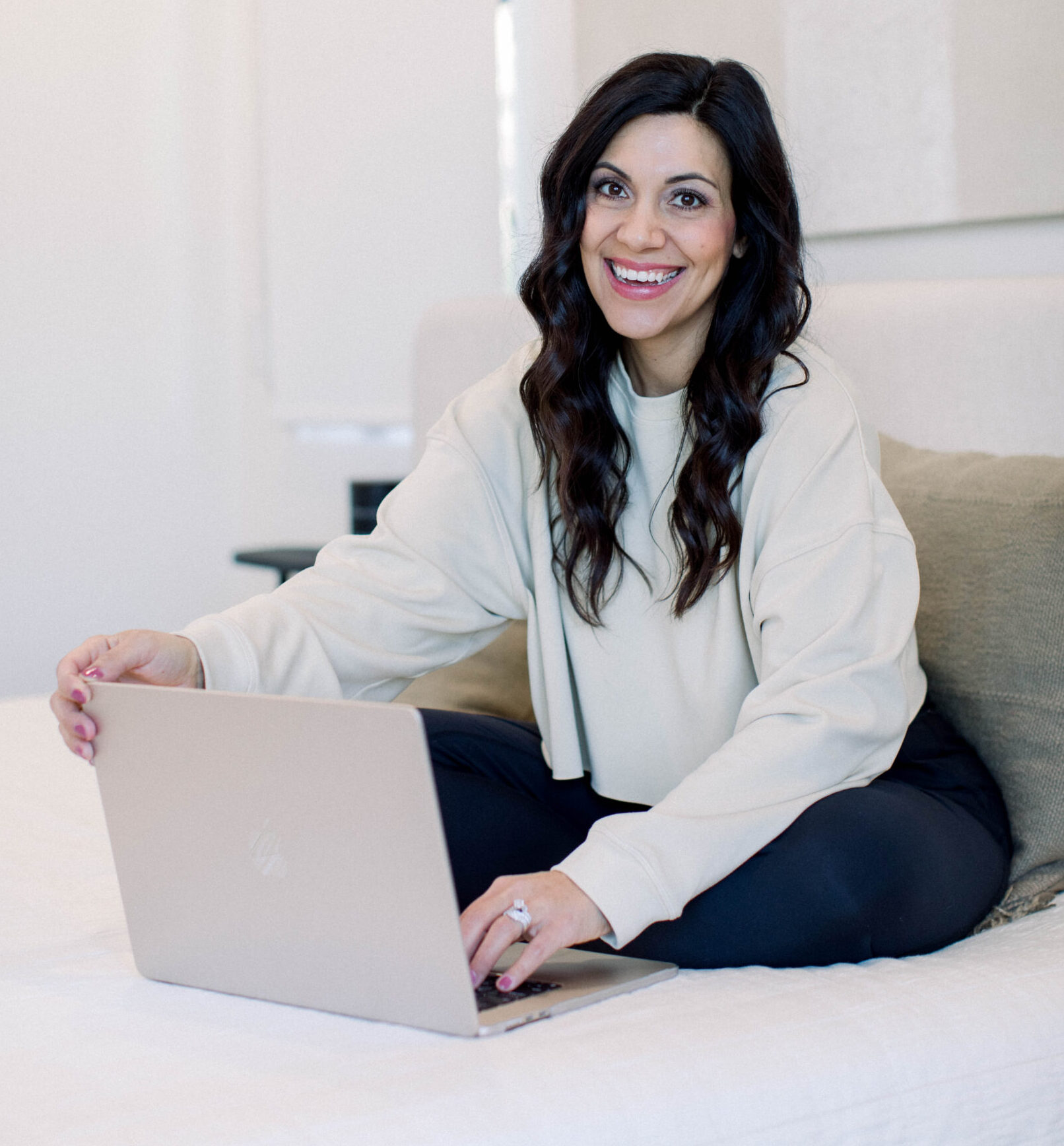 brown haired smiling woman sitting with her laptop