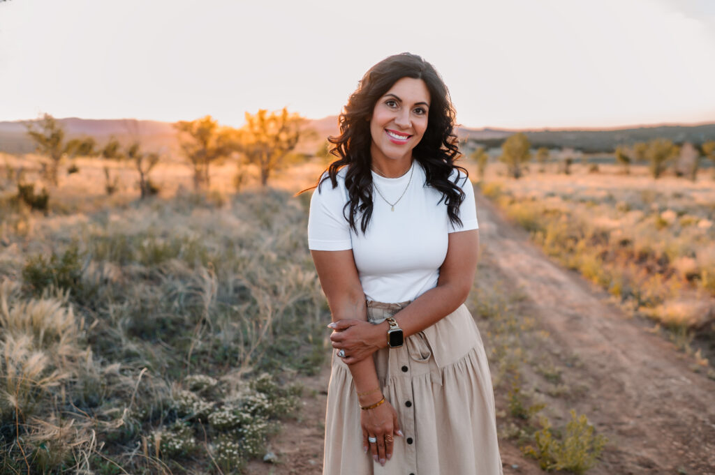 A brunette woman smiling in the desert, wearing a white t-shirt and a tan skirt. The title of the post is: Weird-Business-Growth-Tips-For-Christian-Creators-799-Stefanie-Gass