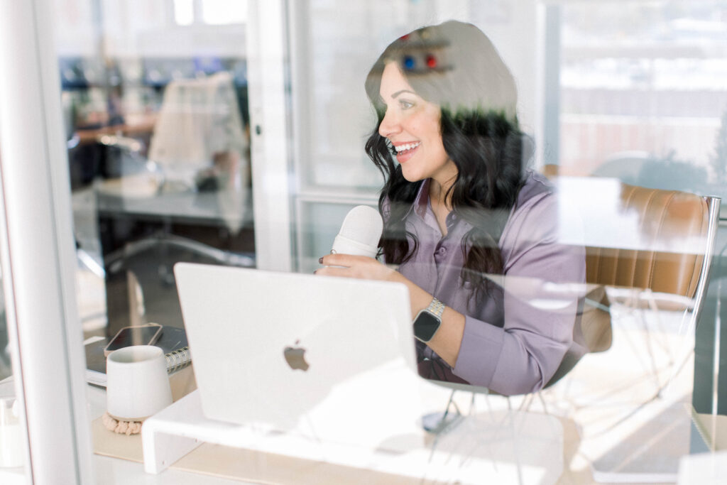 speaking-through-microphone-smiling-looking-away-from-camera-stefanie-gass The image title is: Ep-828-Seasons-of-Scaling-What-to-Prioritize-at-Every-Revenue-Milestone-Stefanie-Gass